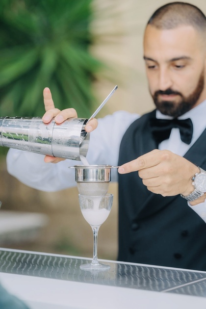 Professional bartender from Philoxenia Events London preparing a signature wedding cocktail for a British couple in Verona, Italy, during a luxury destination celebration